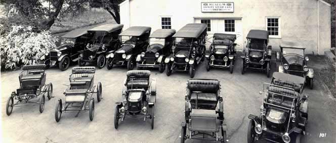 An old, black & white photo of Stanley cars in front of the Marshall Steam Museum building