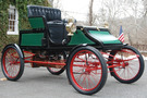 The 1905 Stanley Model CX looks similar to a buggy, has an open top, has a green body and red wheel spokes/undercarriage 