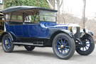 The 1916 Stanley Model 725 has a cobalt blue body and wheel spokes. The top is up, and it covers both the top and sides of the car