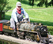 The Northern Engine #401 is being operated by a man in an engineer outfit, the train is mostly black and has the words "Auburn Valley" painted on the side