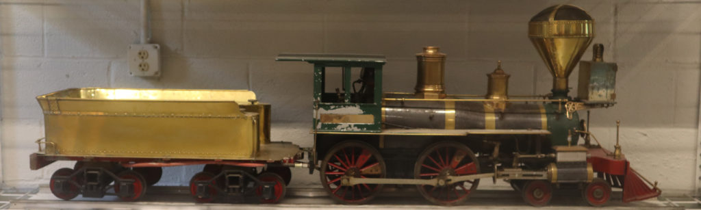 The 4-4-0 American Locomotive is a mostly green train, with gold detailing and a gold car behind it