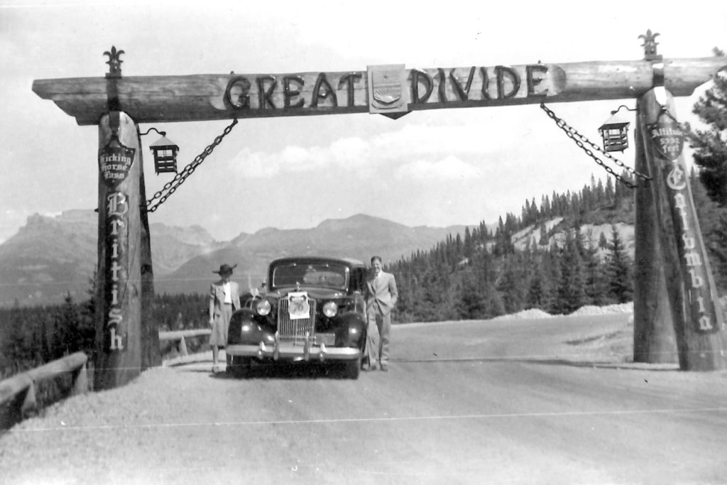 An older woman and a younger man stand on opposite sides of the Model 1508, underneath a wooden post that reads "Great Divide"