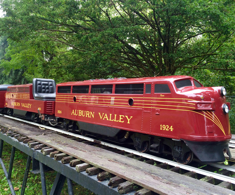 The F-7 Double Unit is a mostly red train with the words "Auburn Valley" painted on the side in yellow